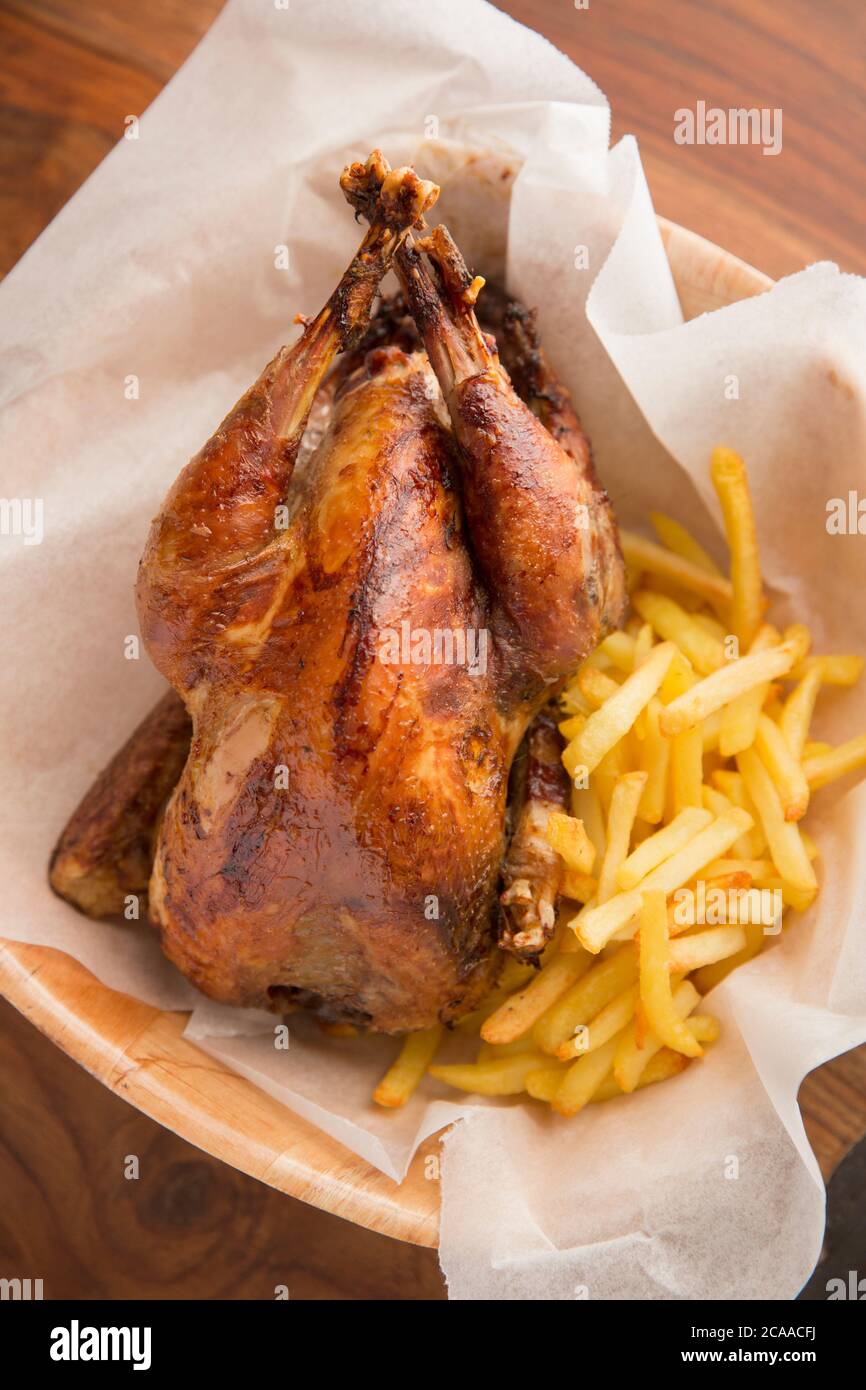 A homecooked pheasant that was shot on a driven pheasant shoot that has been roasted and served with chips in a basket as an alternative to the popula Stock Photo
