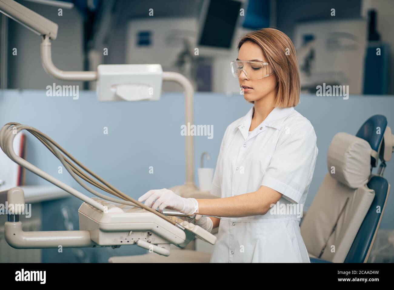 serious concentrated dentist woman at work, use special instrument equipment for teeth treatment, health care provider Stock Photo