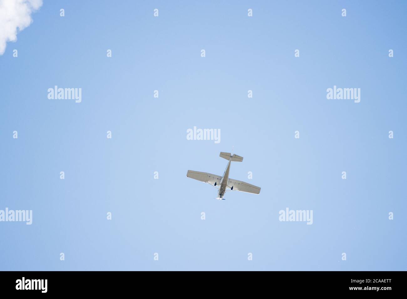 in the blue cloudless sky a small white propeller plane flies Stock ...