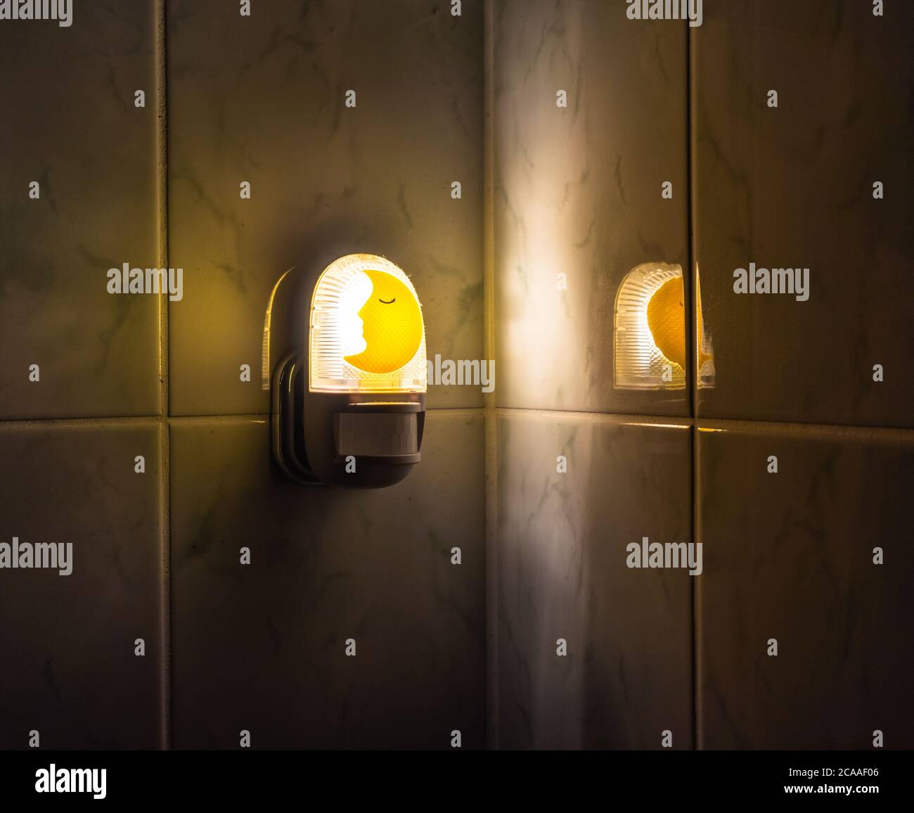 A night light with a sensor detecting movement switched on inside a dark bathroom Stock Photo ...
