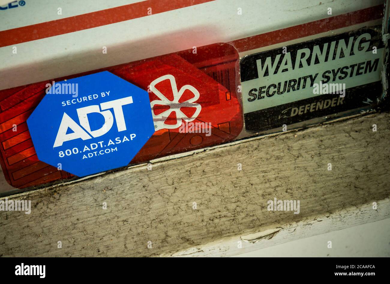 A decal informing would-be burglars that a store in Greenwich Village in New York is protected by the security firm ADT is seen on Monday, August 3, 2020. Google announced it has bought a 6.6% stake in ADT Inc., in a $450 million deal. ADT will be able to service Google’s Nest home security. (© Richard B. Levine) Stock Photo