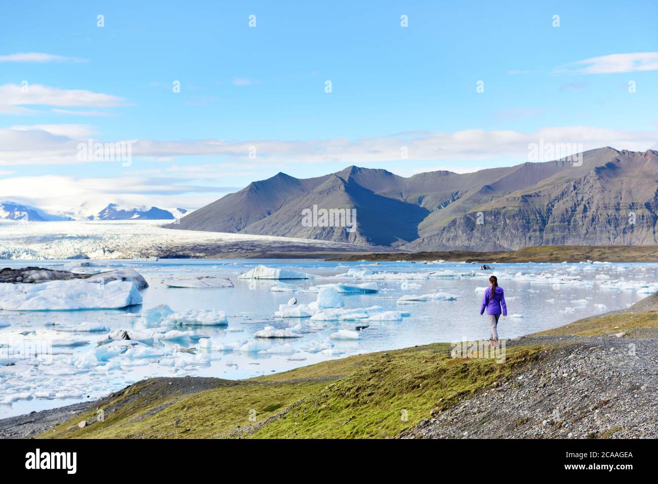 Iceland travel tourist enjoying view of nature landscape Jokulsarlon glacial lagoon / glacer lake on Iceland. Woman outdoors by tourist destination Stock Photo