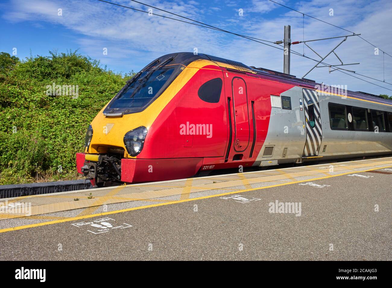 Arriva Pendalino train still in Virgin livery at Milton Keynes station with stay safe, stay apart instructions on the platform. Note the stone chip da Stock Photo