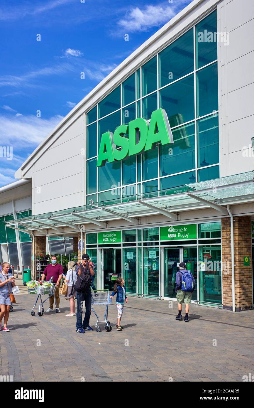 ASDA shop in the centre of Rugby with Covid-19 messages on door and person in facemask with trolley Stock Photo