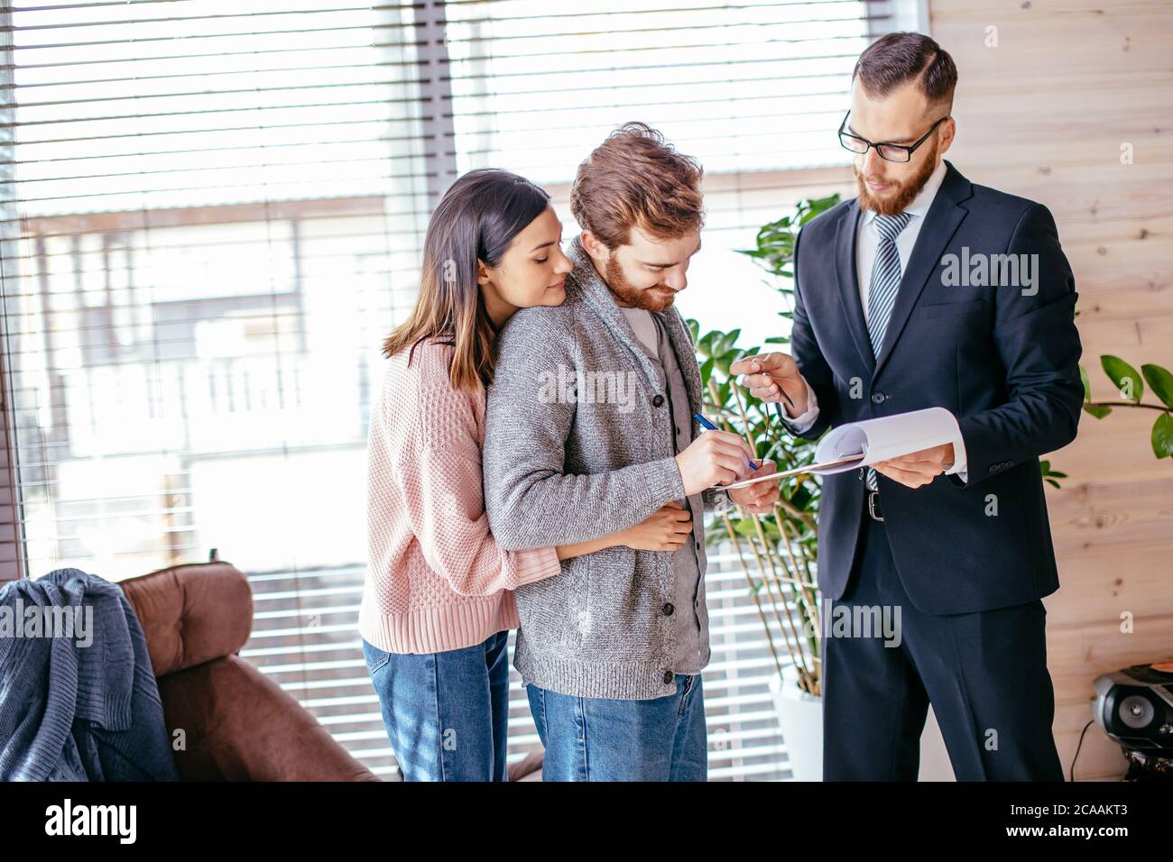 Smiling caucasian couple of attractive tenants shaking hands with
