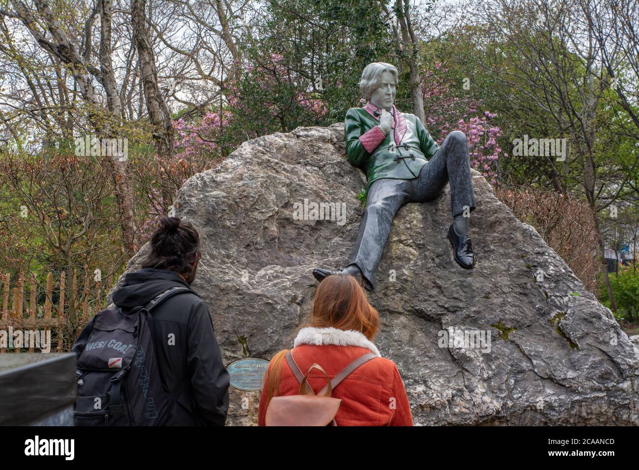 Tourists viewing Oscar Wilde statue in Merrion Square in Dublin Ireland Stock Photo