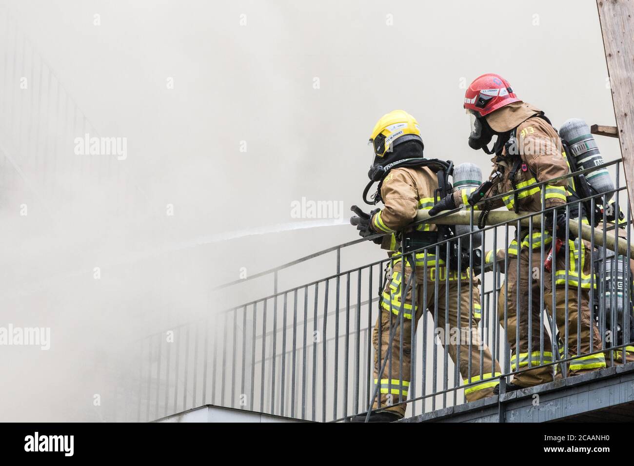 Firefighter spray water on fire with hose Stock Photo Alamy