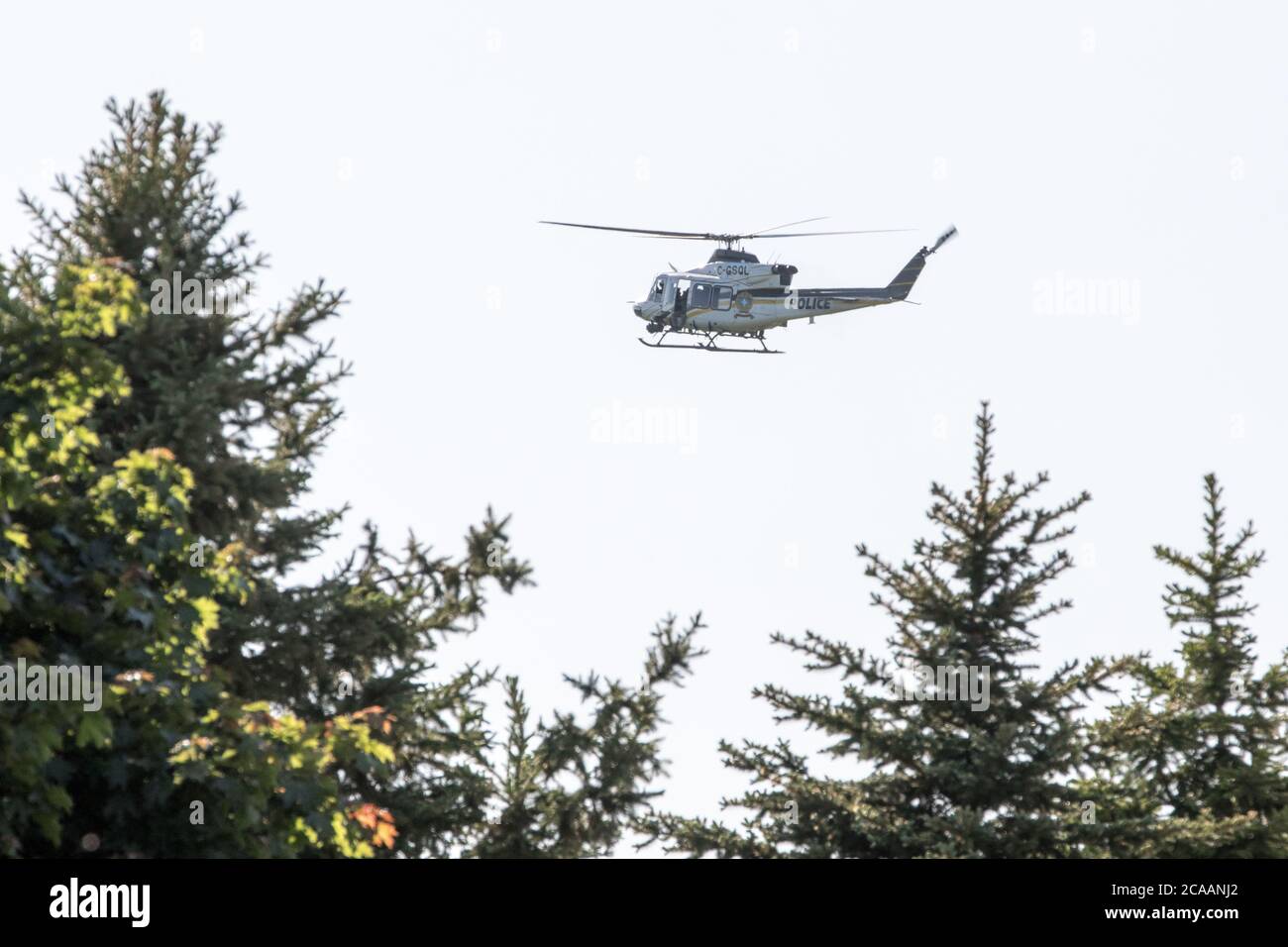 Helicopter search and rescue above trees Stock Photo