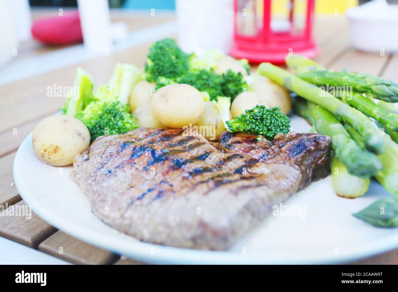 steak, brocolli and veg dinner in the garden outside in the summer Stock Photo