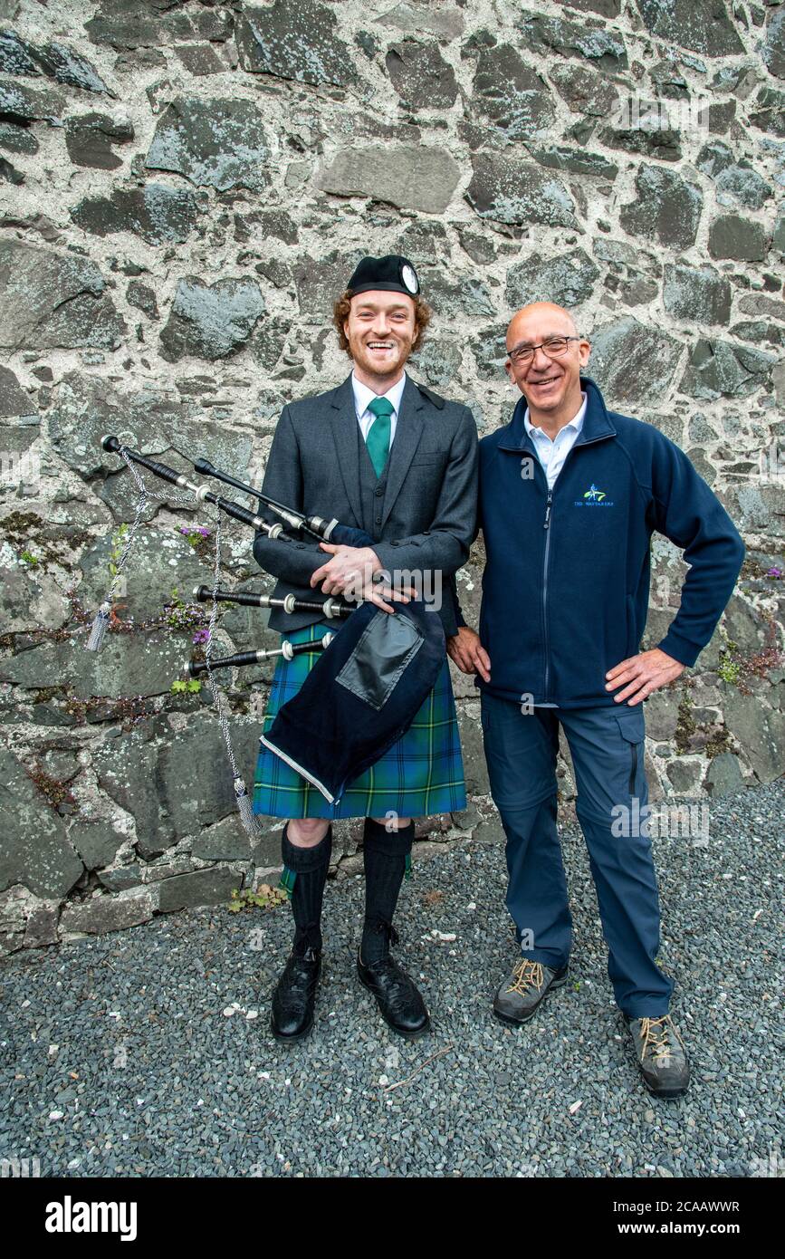 Scottish Borders walking program. Father and son with bagpipes in front of a local pub, Peebles, Scotland Stock Photo