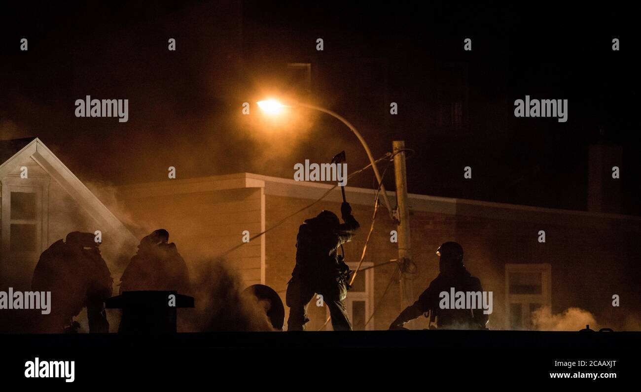 Firefighter using axe on roof stock photo alamy