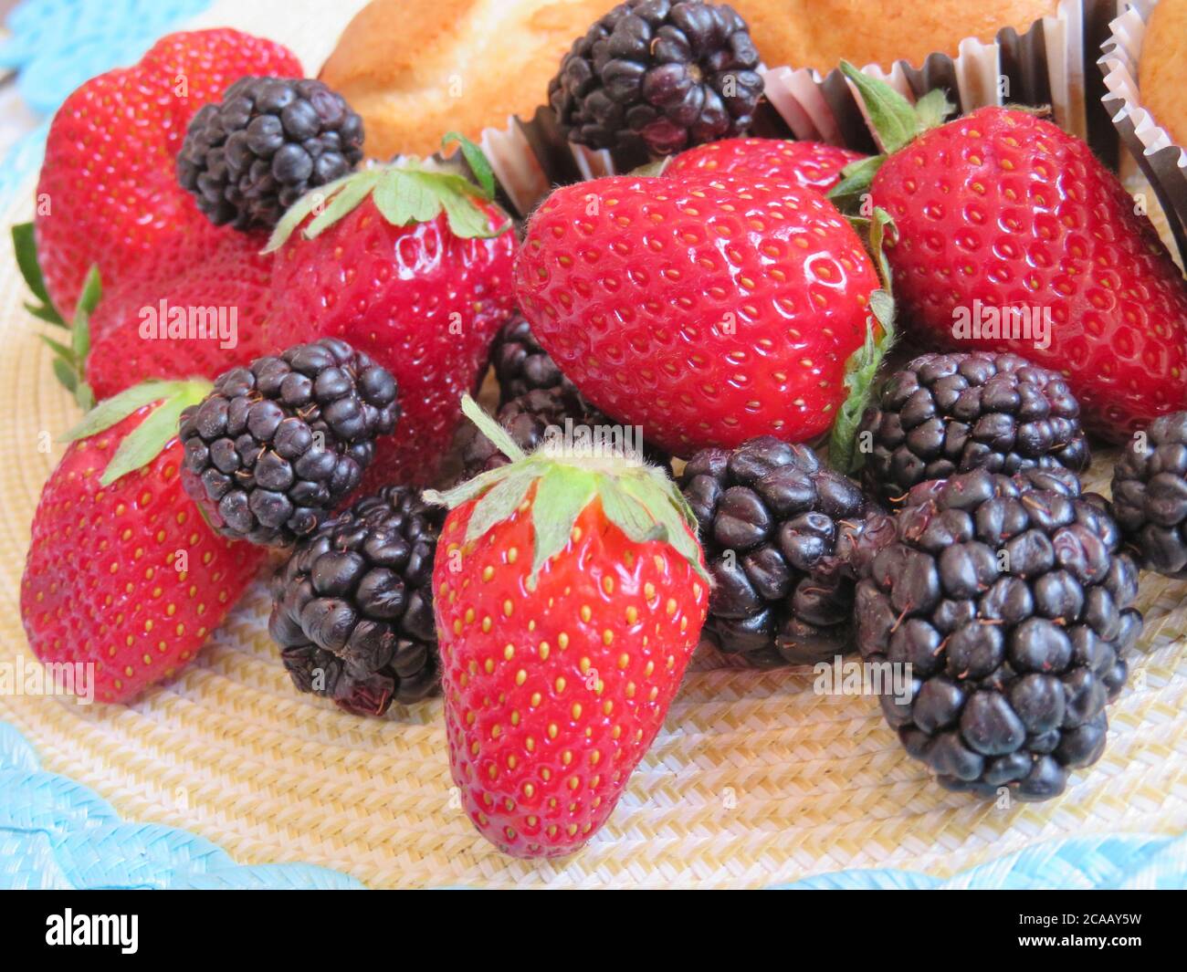 An assortment of berries; fresh, ripe strawberries and blackberries Stock Photo