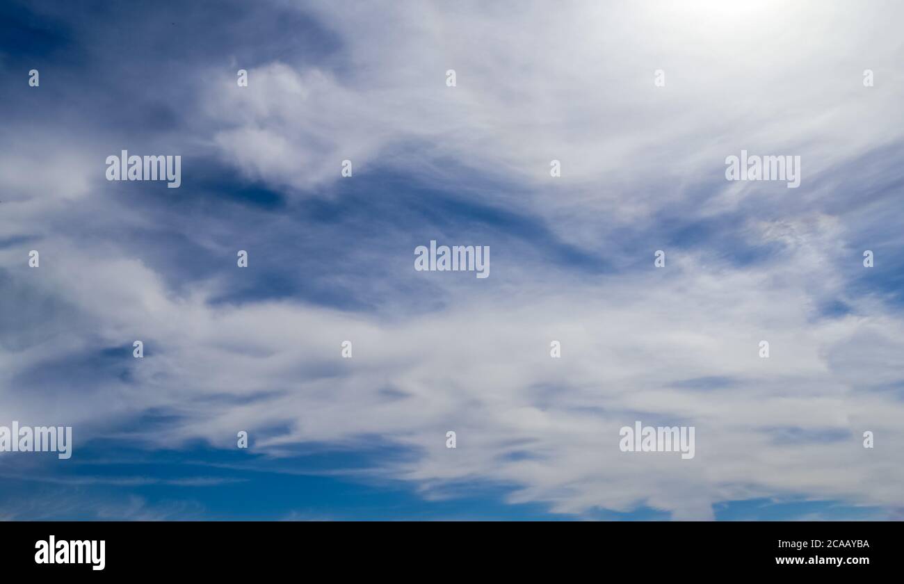 Stunning cirrus cloud formation panorama in a deep blue summer sky seen ...