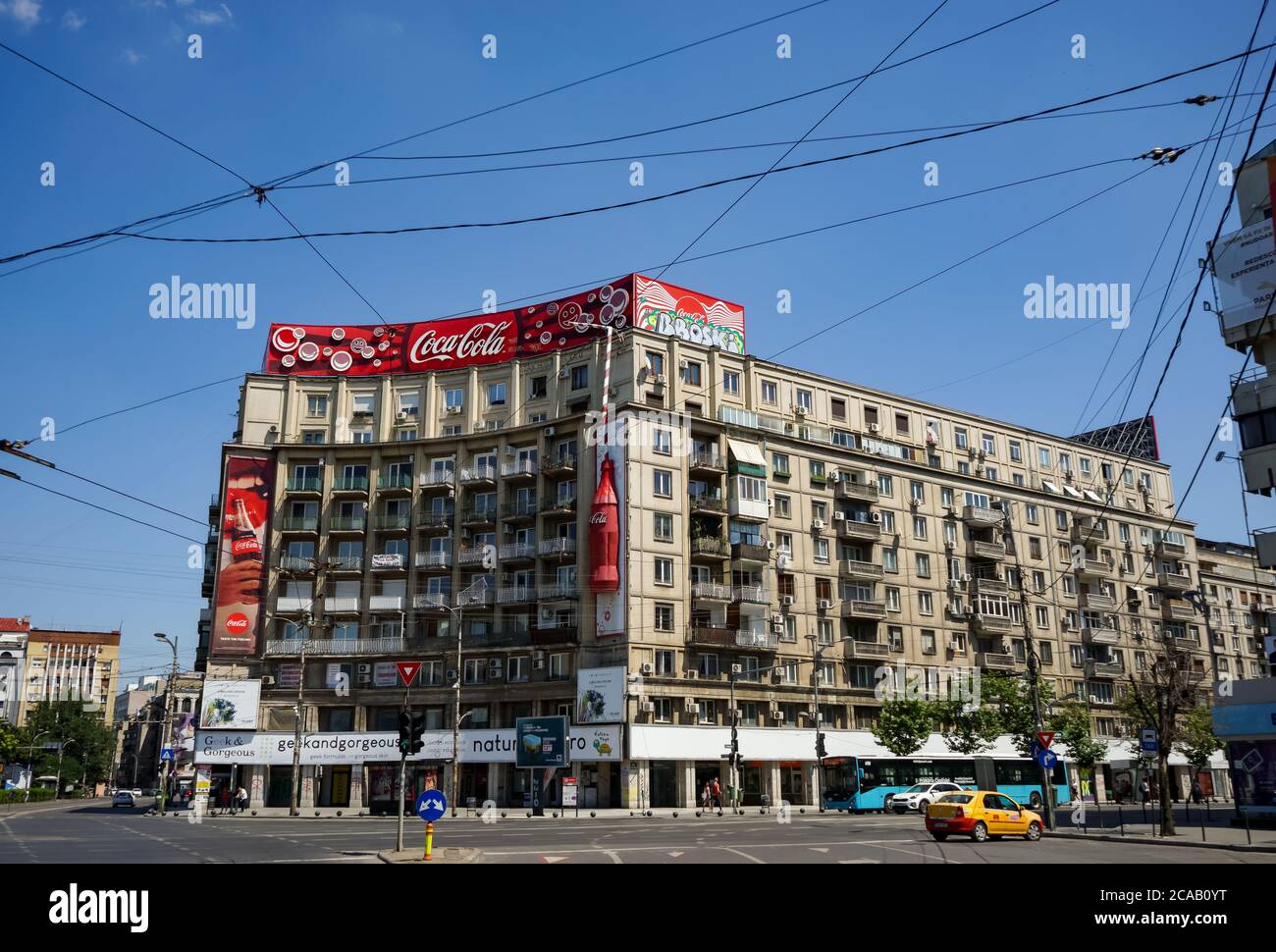Bucharest, Romania -  June 28, 2020: A very large logo of Coca-Cola soft drink manufacturer is displayed on the top of a block of flats, in Piata Roma Stock Photo