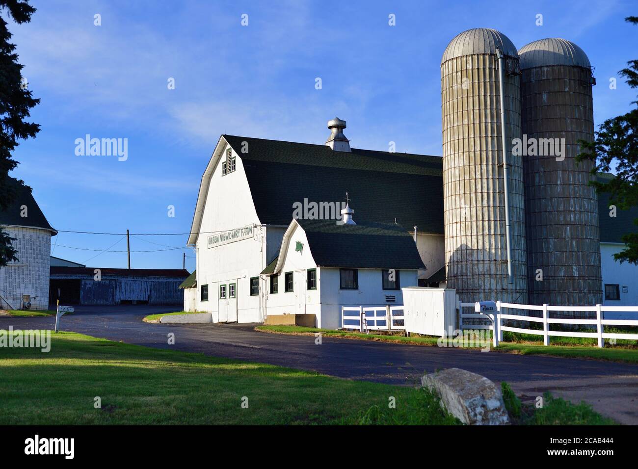 Virgil, Illinois, USA. A dairy farm barn and silos bask in the late