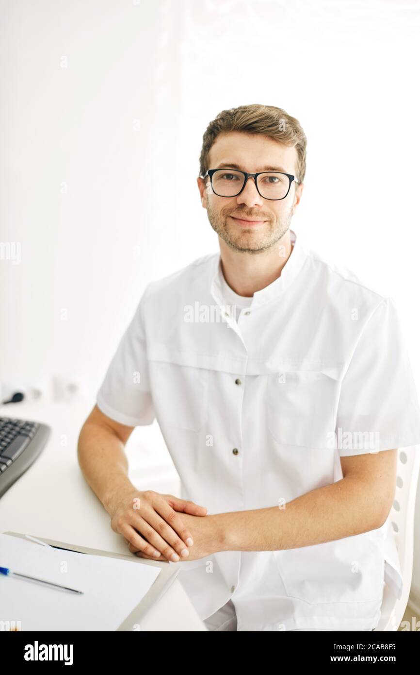 Portrait with copy space of cheerful joyful doctor in white uniform