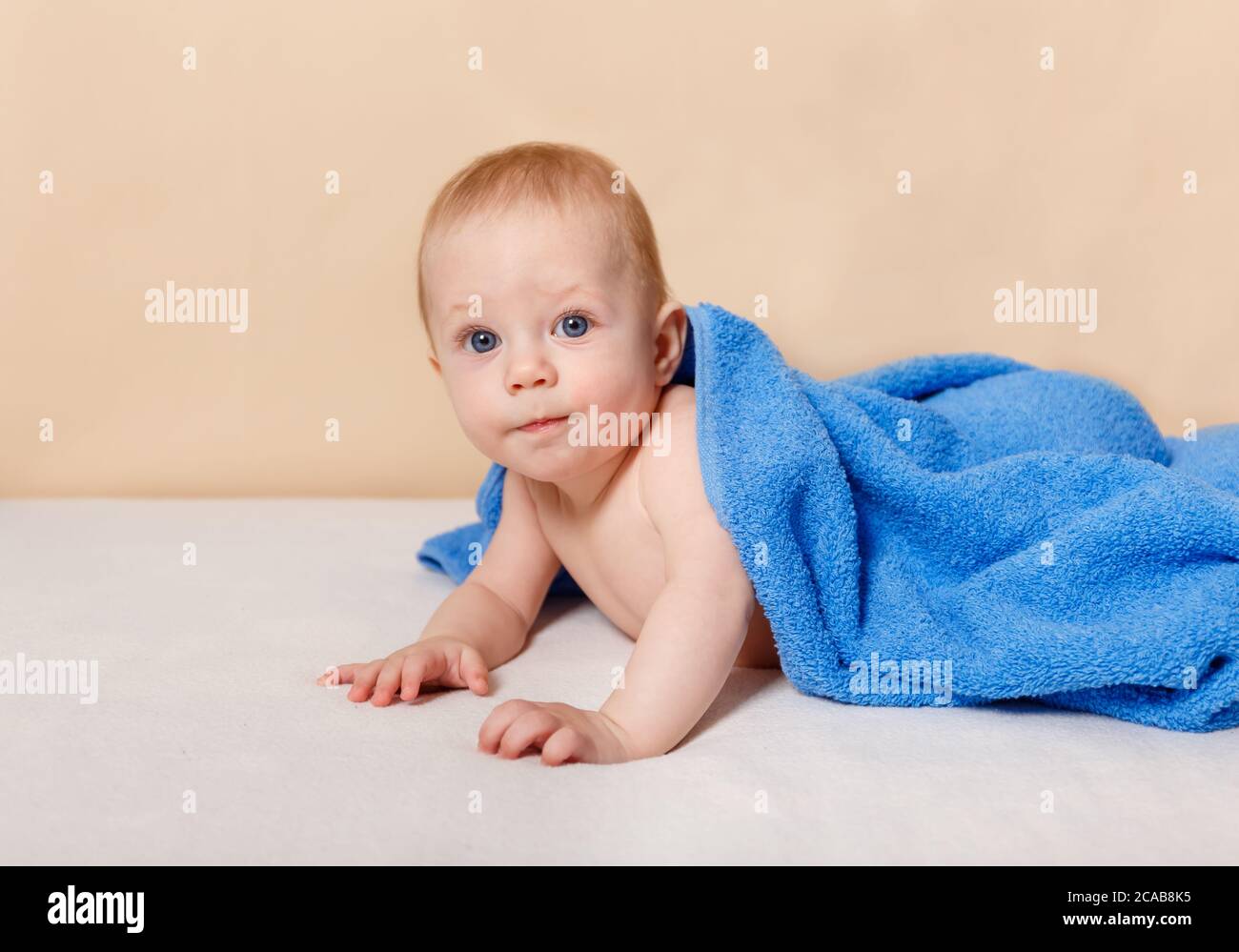 Happy Six Month Old Baby Lying Under The Towel On A Bed And Having Fun Stock Photo Alamy