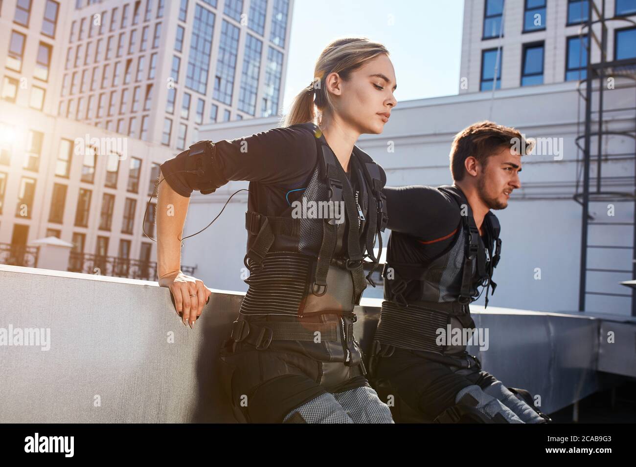 https://c8.alamy.com/comp/2CAB9G3/close-up-side-view-photo-of-an-active-young-people-in-ems-costumes-leaninh-on-the-wall-and-doing-exercises-copy-space-strength-tiredness-2CAB9G3.jpg