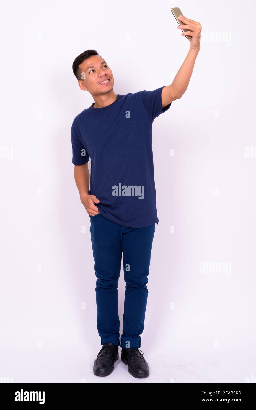 Portrait of happy young Asian man taking selfie Stock Photo