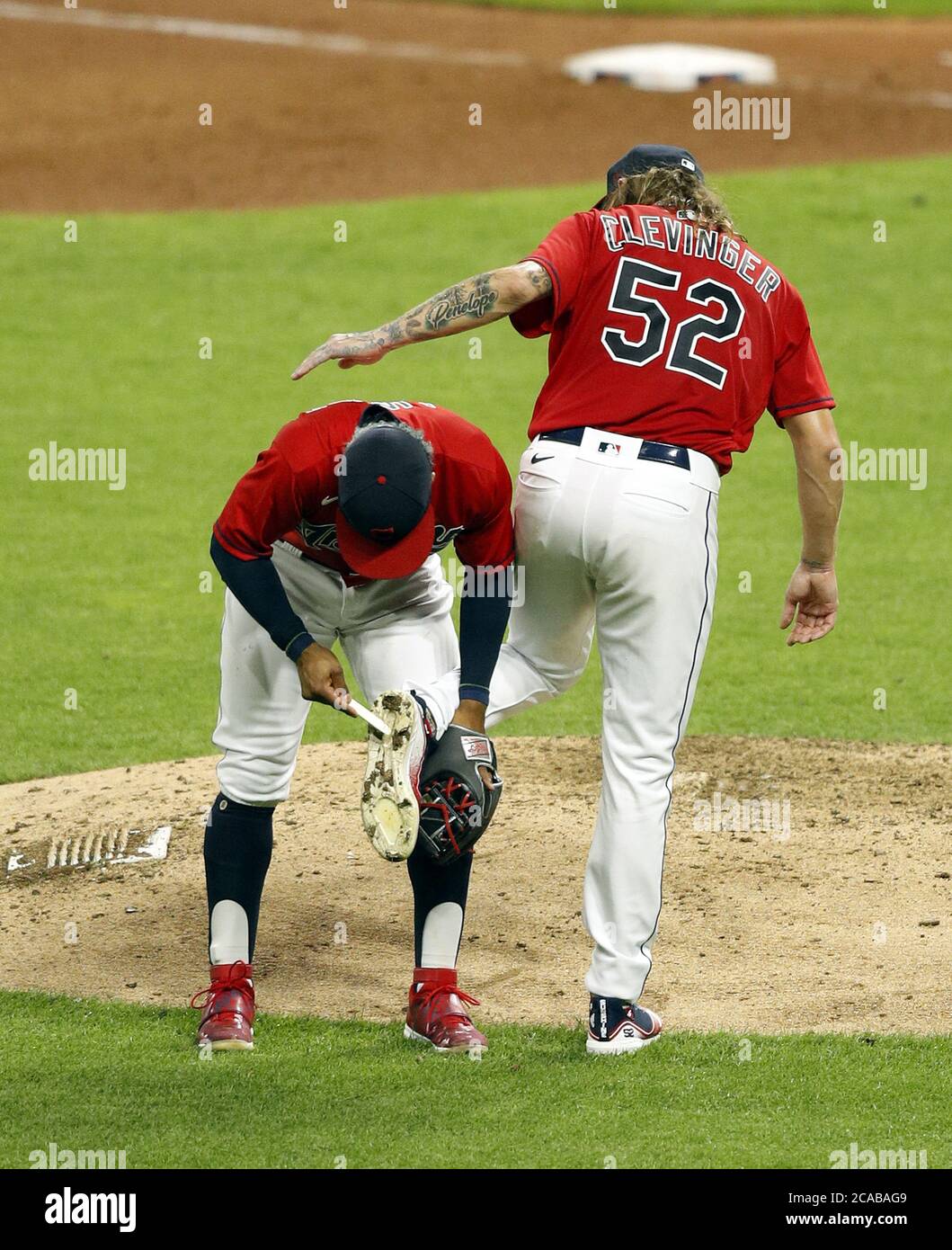 Cleveland, United States. 05th Aug, 2020. Cleveland Indians Francisco Lindor  (12) cleans the cleats of pitcher Mike Clevinger (52) during the sixth  inning against the Cincinnati Reds at Progressive Field in Cleveland