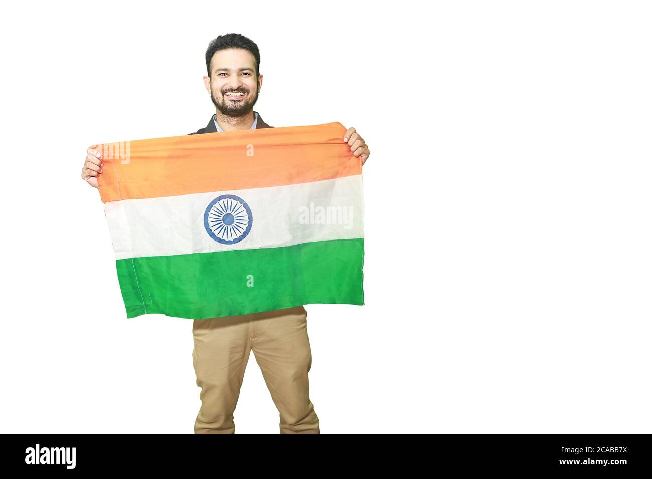 Happy young man holding indian national tricolor flag with smile and showing patriotism, republic day or independence day concept isolated on white ba Stock Photo