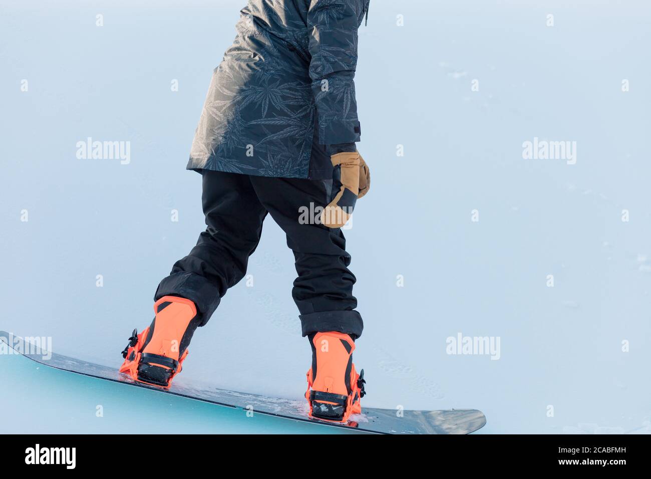 close up cropped photo. guy is on the snowboard. position for snowboarding. strong legs. balance. coordination, man controlling his body during snowbo Stock Photo