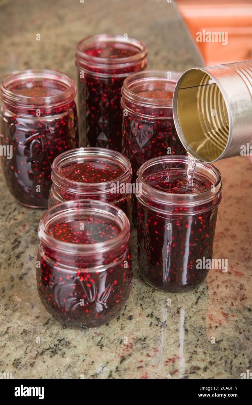Pouring Melted Household Wax Paraffin Onto The Tops Of Blackberry Jam Jars To Seal The Contents Stock Photo Alamy