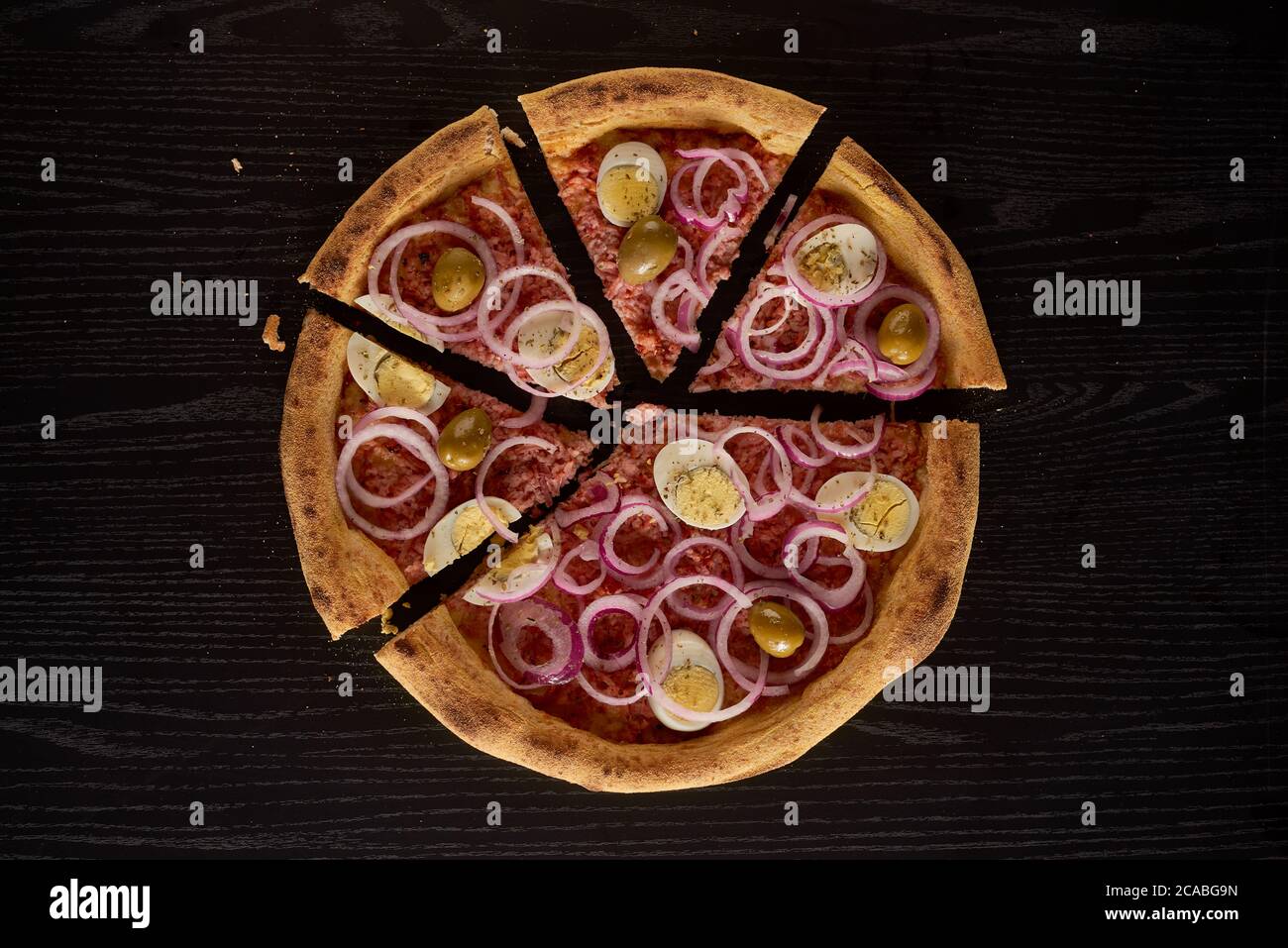 onion, eggs pizza on black background sliced and isolated Stock Photo