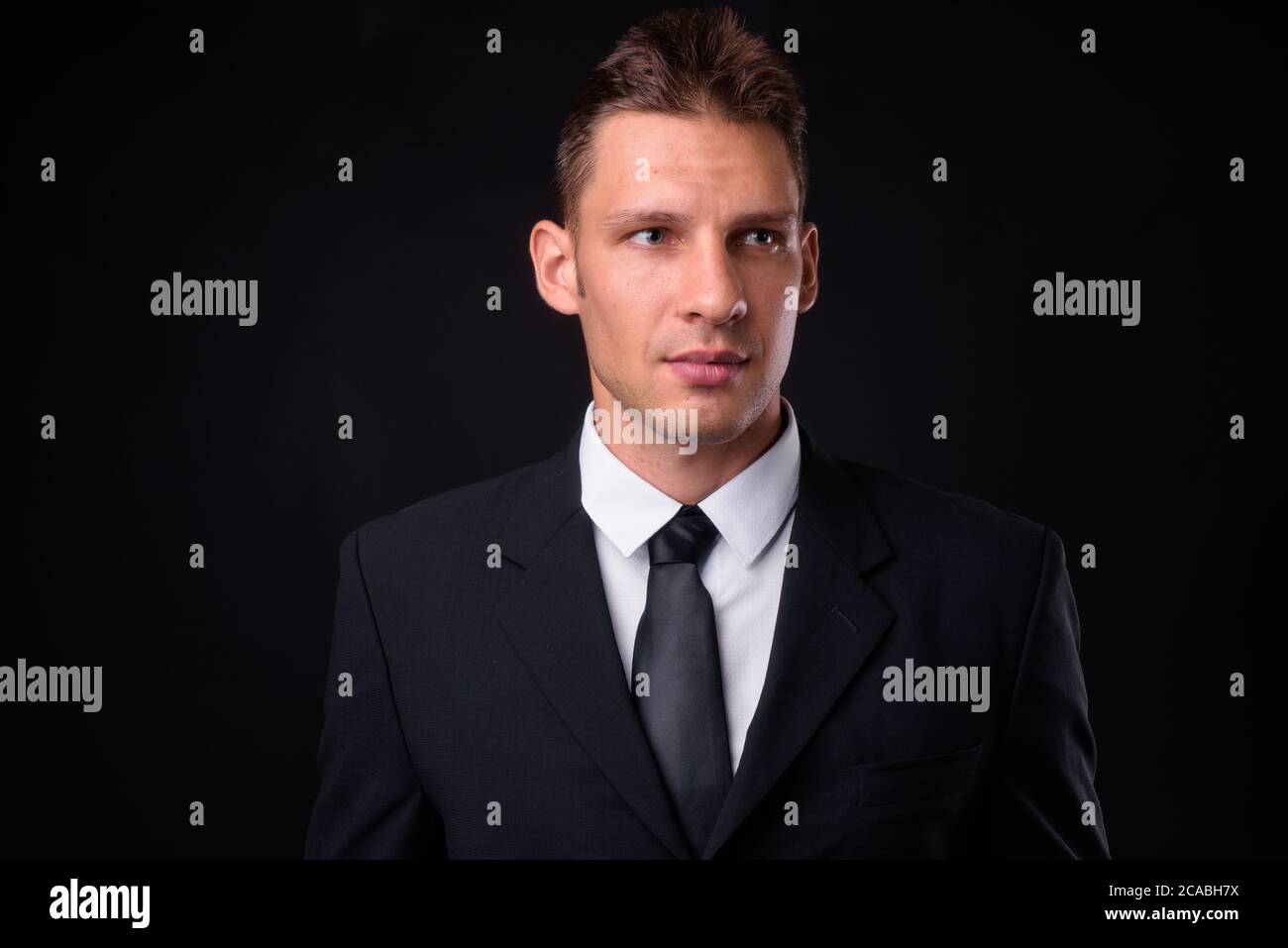 Portrait of businessman in suit against black background Stock Photo