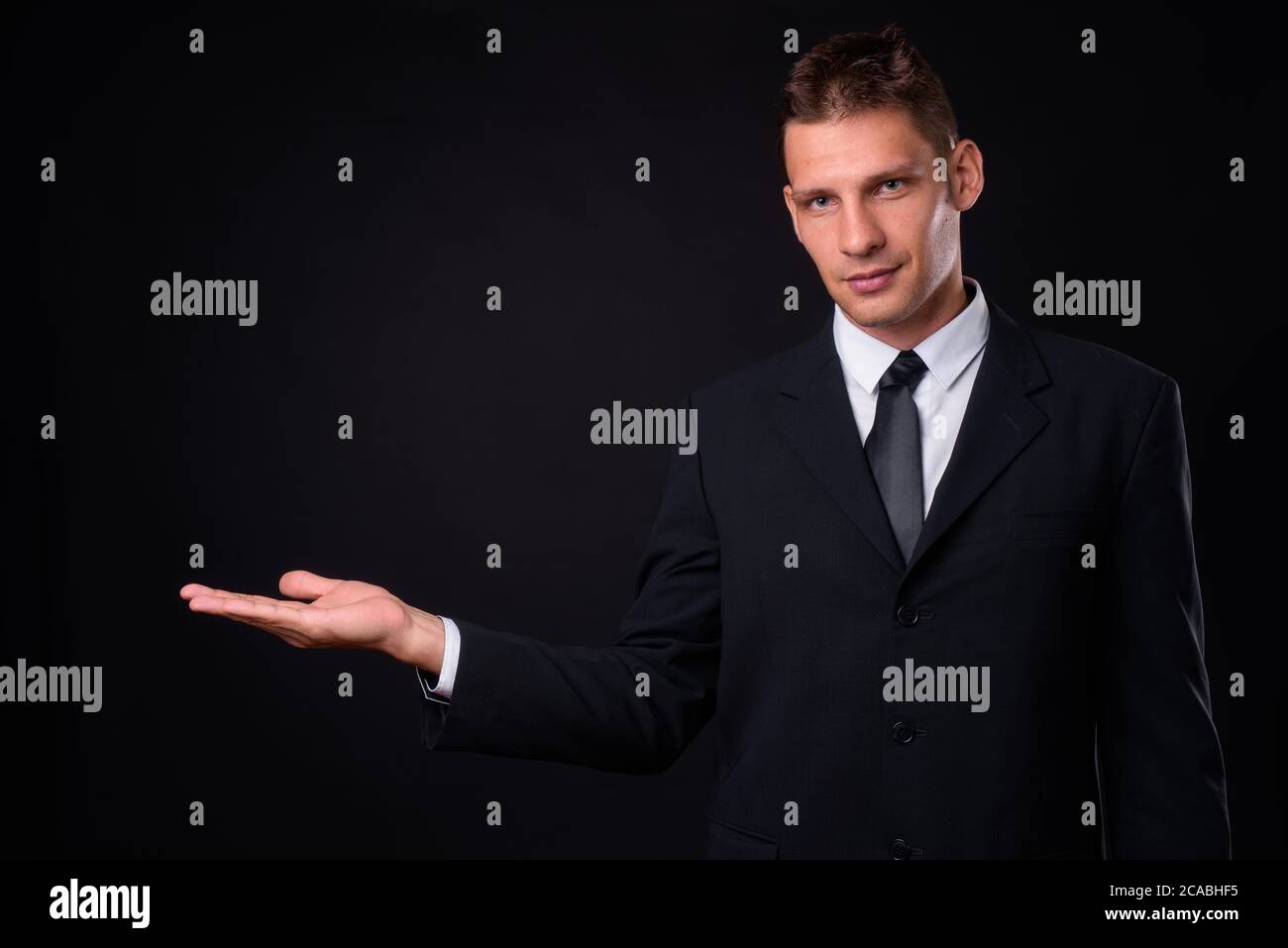 Portrait of businessman in suit against black background Stock Photo ...