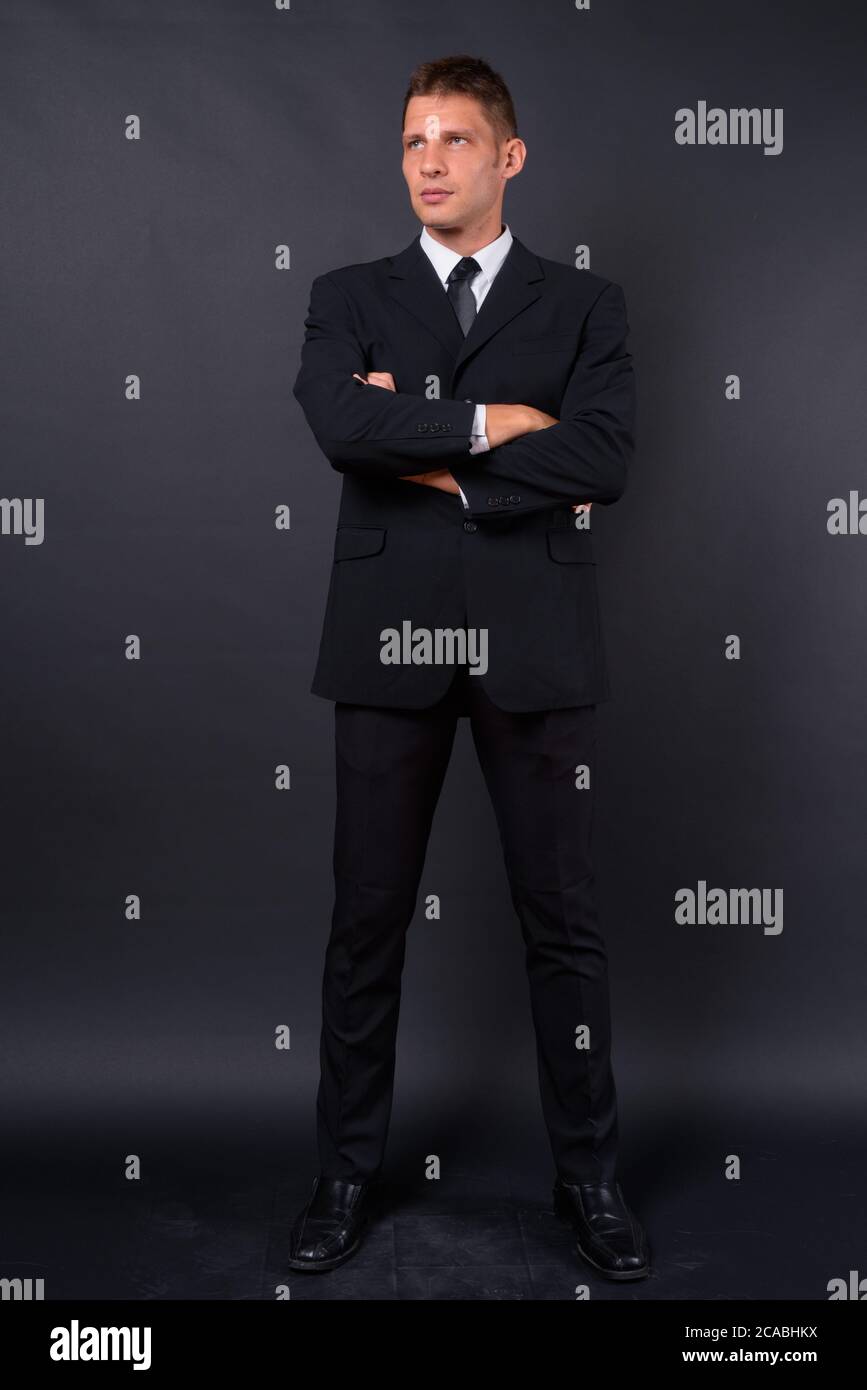 Portrait of businessman in suit against black background Stock Photo ...