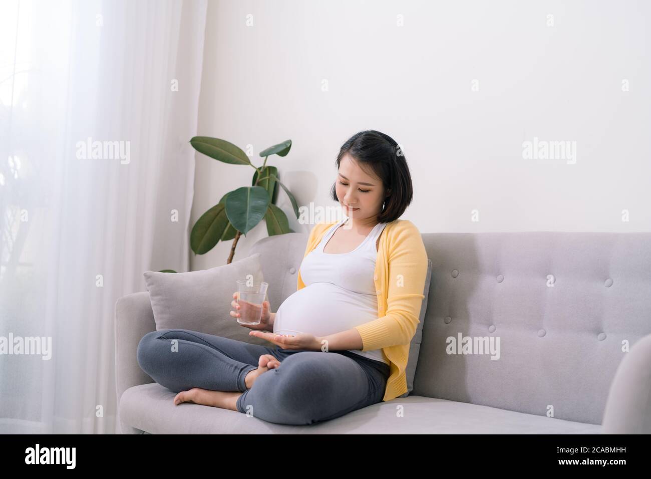 Young pregnant woman taking medicine Stock Photo