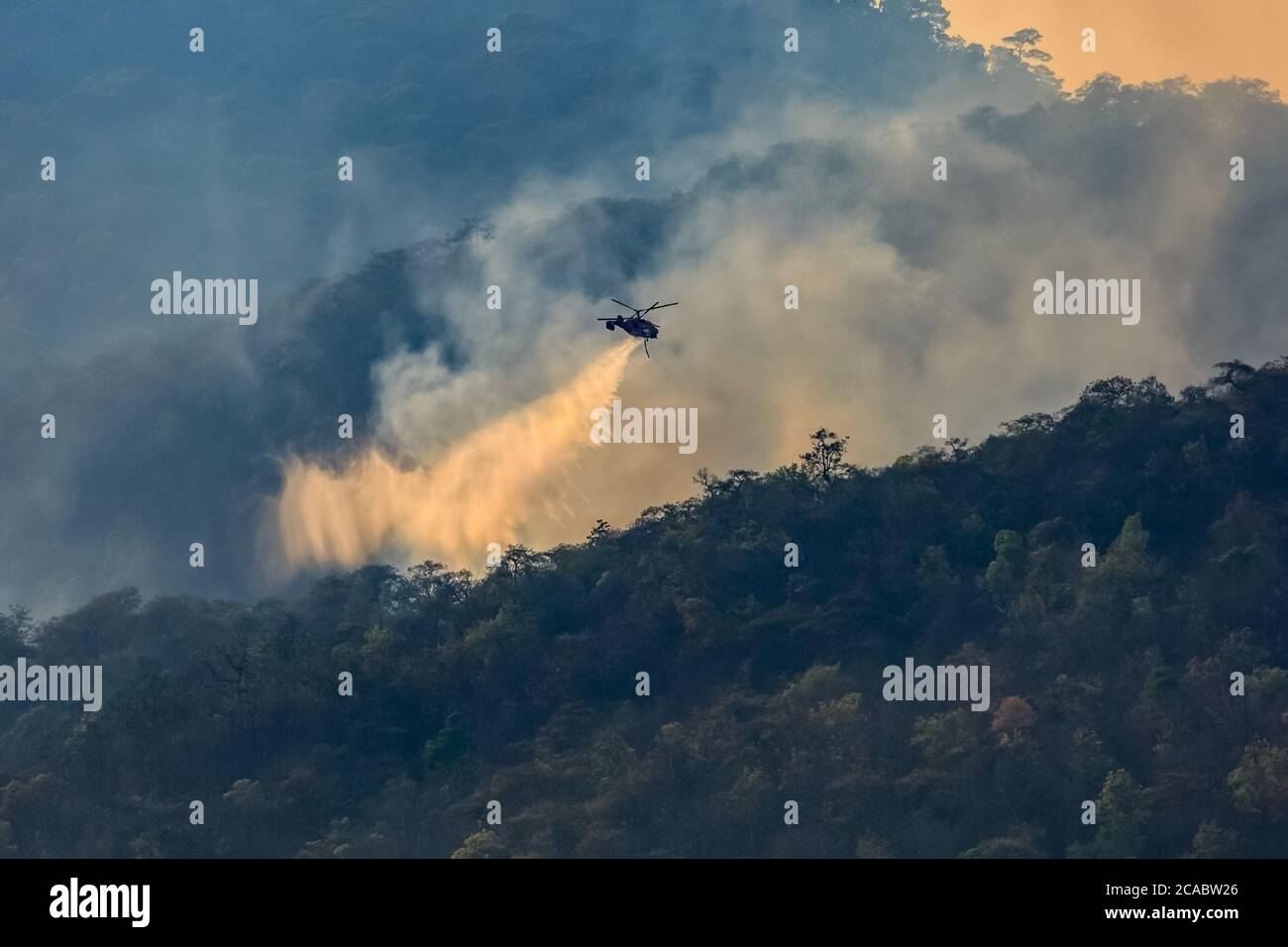Firefighting helicopter dropping water on forest fire Stock Photo Alamy