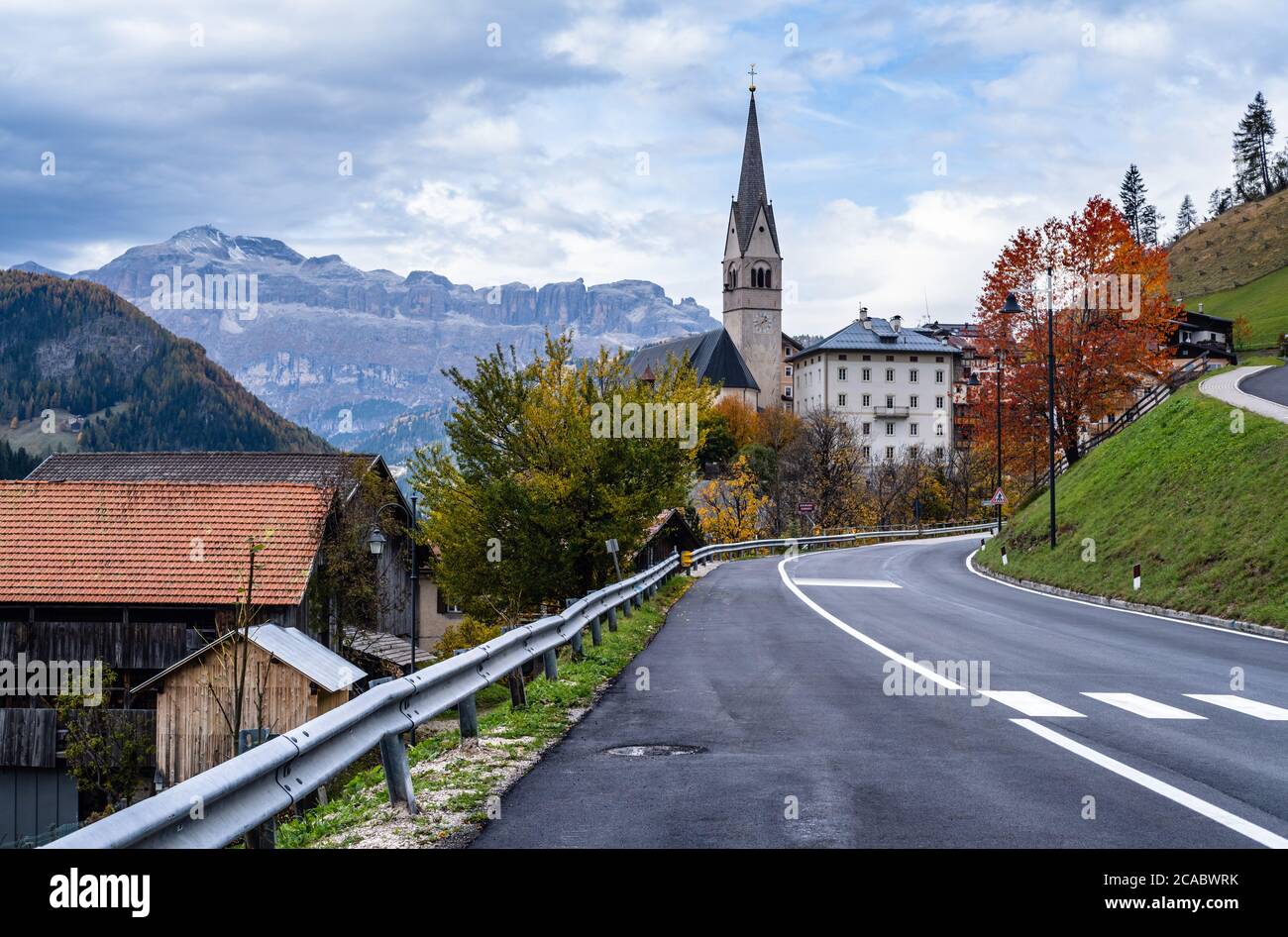 Autumn alpine Dolomites scene, Sudtirol, Italy. Peaceful village and old church view from road, Localita Soraru, Livinallongo del Col di Lana, Belluno Stock Photo
