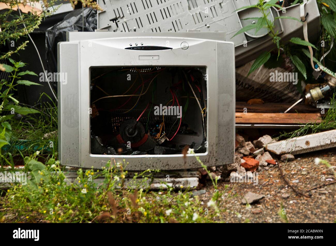 broken computer monitor abandoned with other electronic garbage Stock
