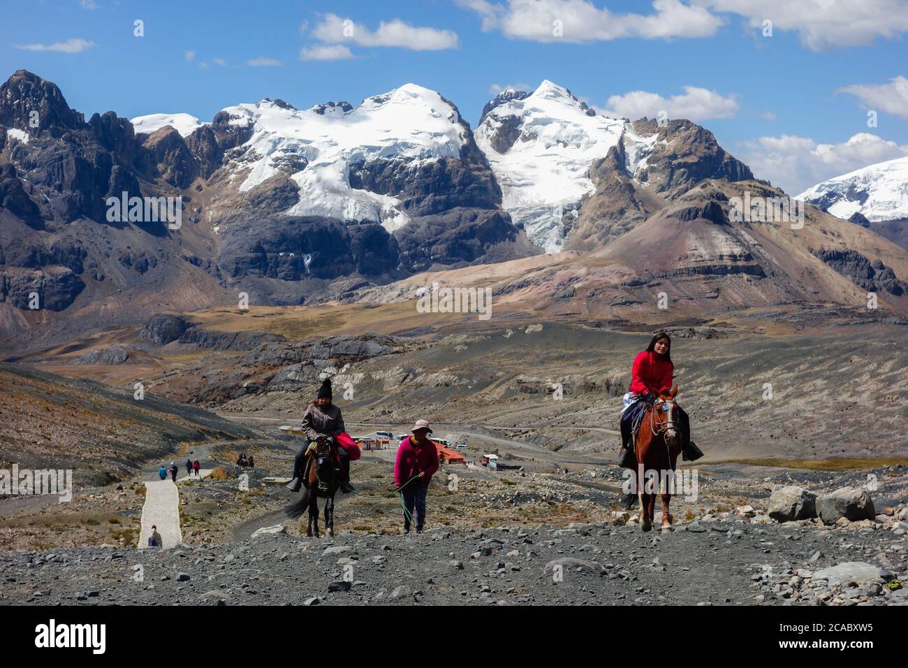 HUARAZ, PERU - Oct 10, 2019: Tourists riding horses to get to Pastoruri Glacier, at Huascaran National Park. Tropical glacier at 5200 meters above sea Stock Photo