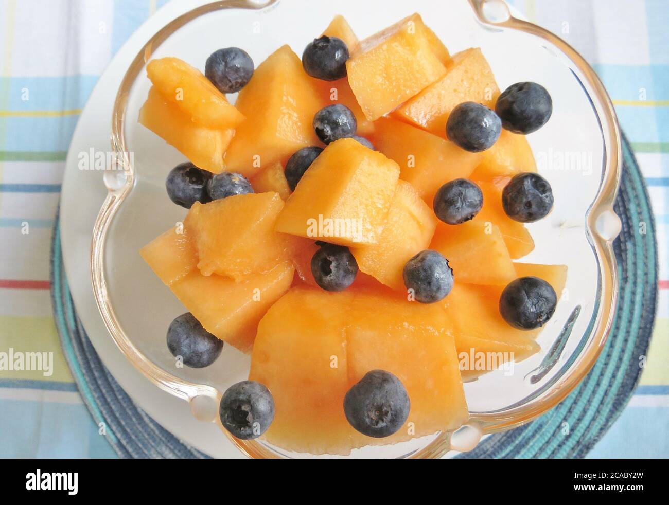 Bowl of sliced cantaloupe and fresh blueberries Stock Photo