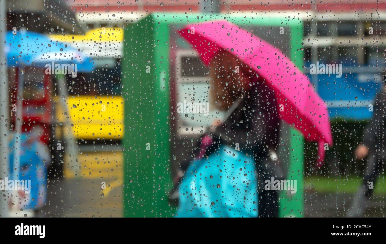 Passerby with umbrella Stock Photo