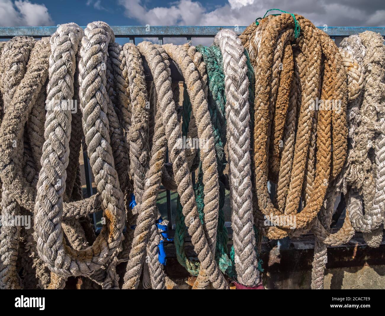 Old mooring lines hung to dry in the harbour Stock Photo