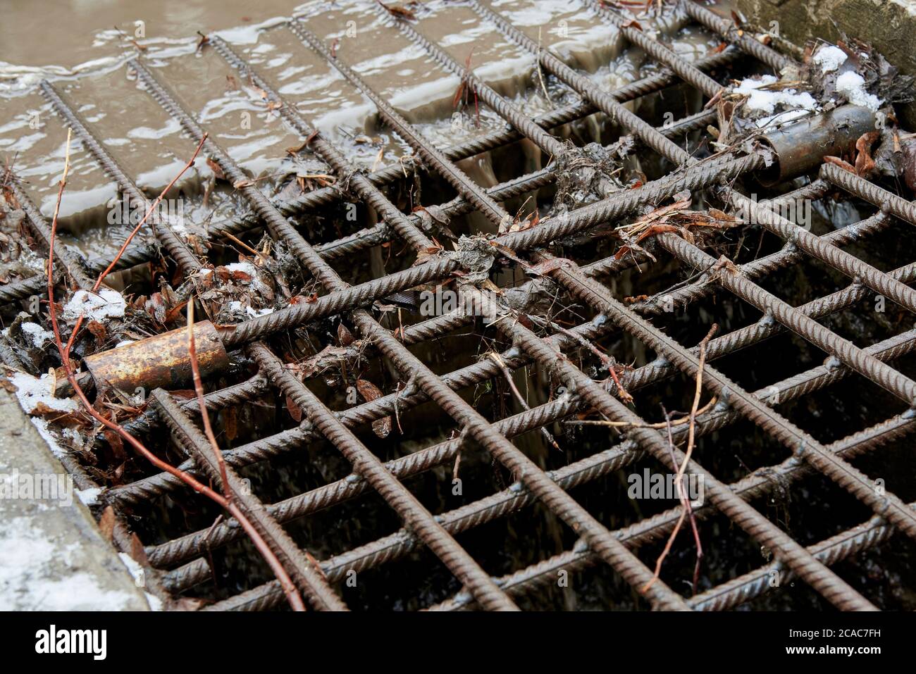 Iron grate for draining water in the city. Old drain ditch. Stock Photo