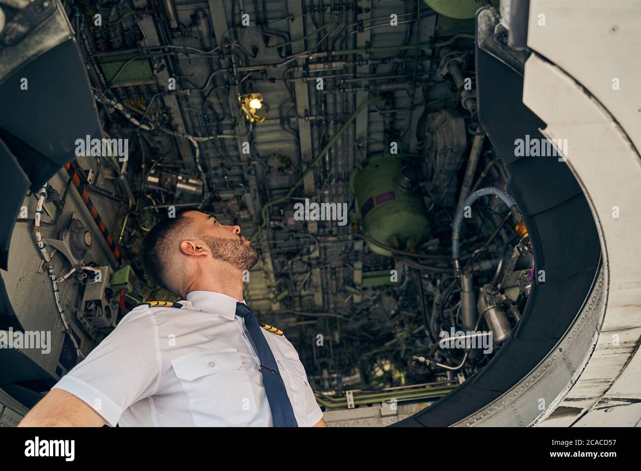 Caucasian airman in uniform inspecting an aircraft Stock Photo
