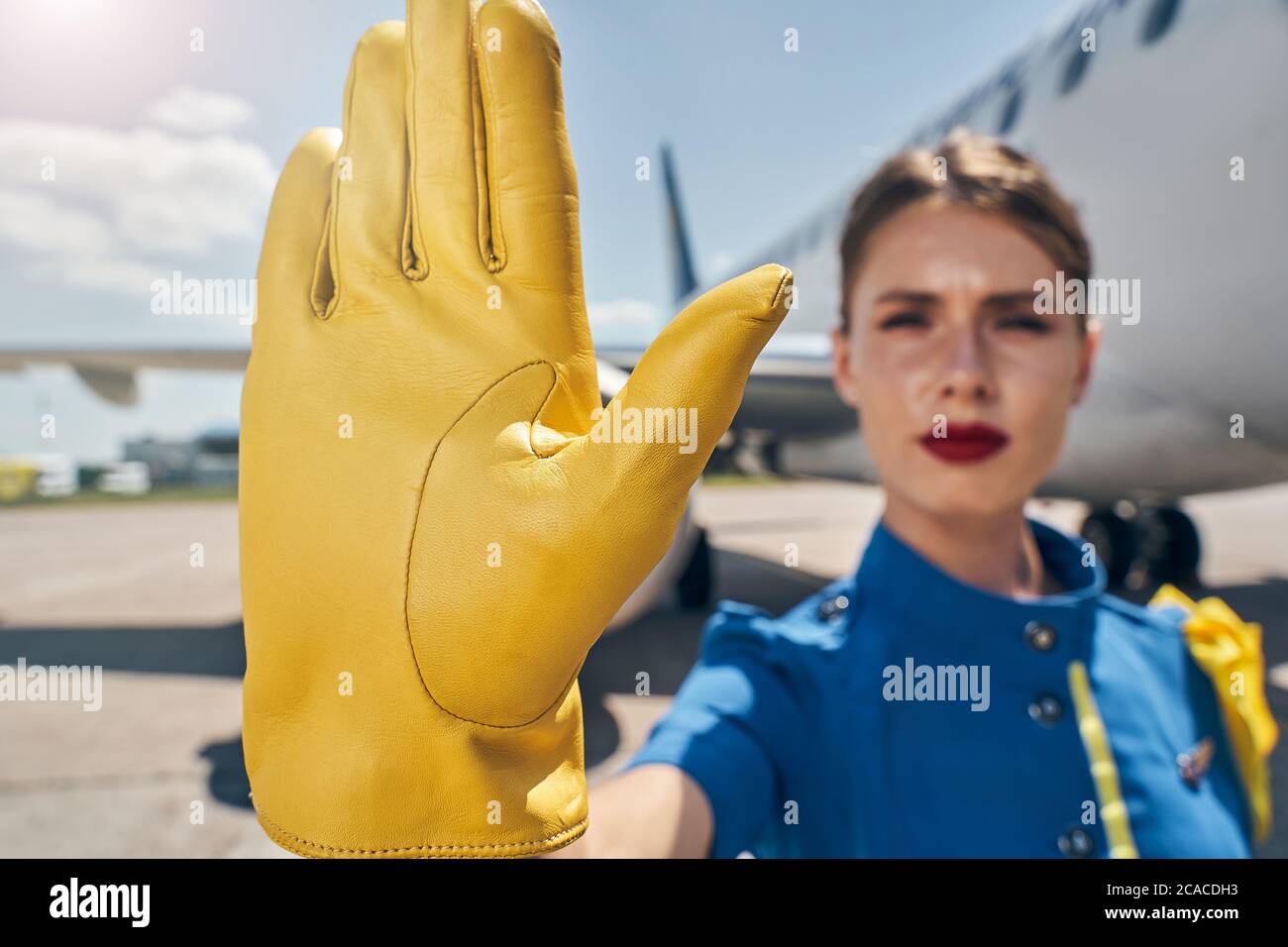 Serious stewardess calling for maintaining social distancing Stock