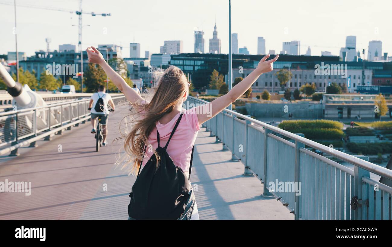 Young woman with backpack. Freedom concept. Rising hands in the air. Pedestal up follow shot. High quality photo Stock Photo