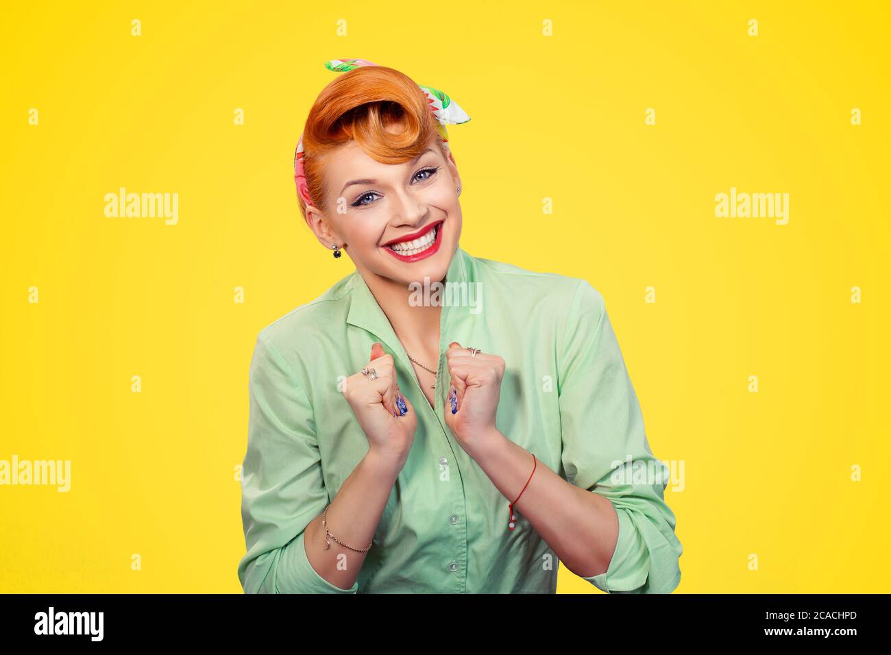 Expecting the success. Young content super excited woman in looking at you happily hands clenched fists in anticipation isolated yellow background ret Stock Photo