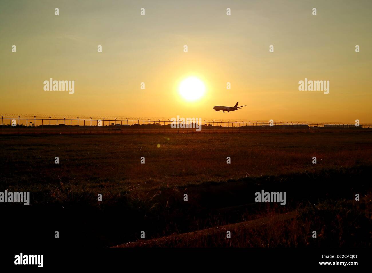 Silhouette of an airplane flying up against sunset sky Stock Photo - Alamy