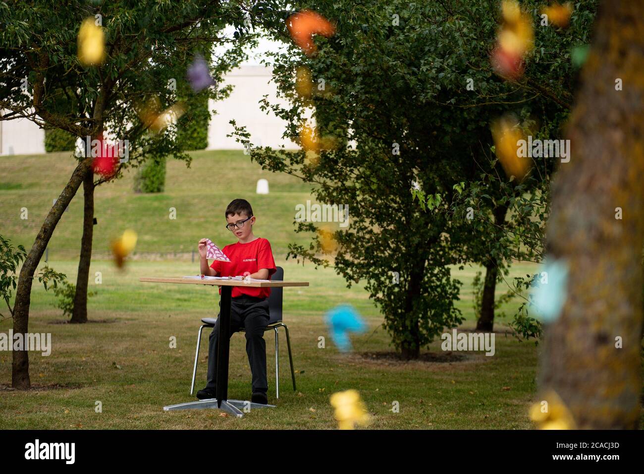 William Saunders, 9, folding origami peace cranes before hanging them in the Anglo-Japanese Grove of Reconciliation at the National Memorial Arboretum in Alrewas, Staffordshire, to mark the 75th anniversary of the atomic bomb being dropped on Hiroshima. Stock Photo