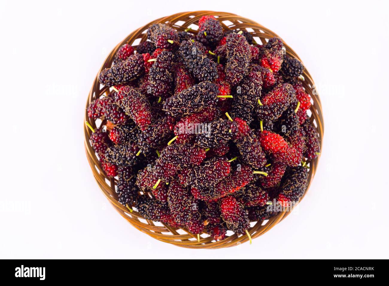 ripe mulberry in  brown basket is a fruit with vitamins. on white background healthy mulberry fruit food isolated Stock Photo