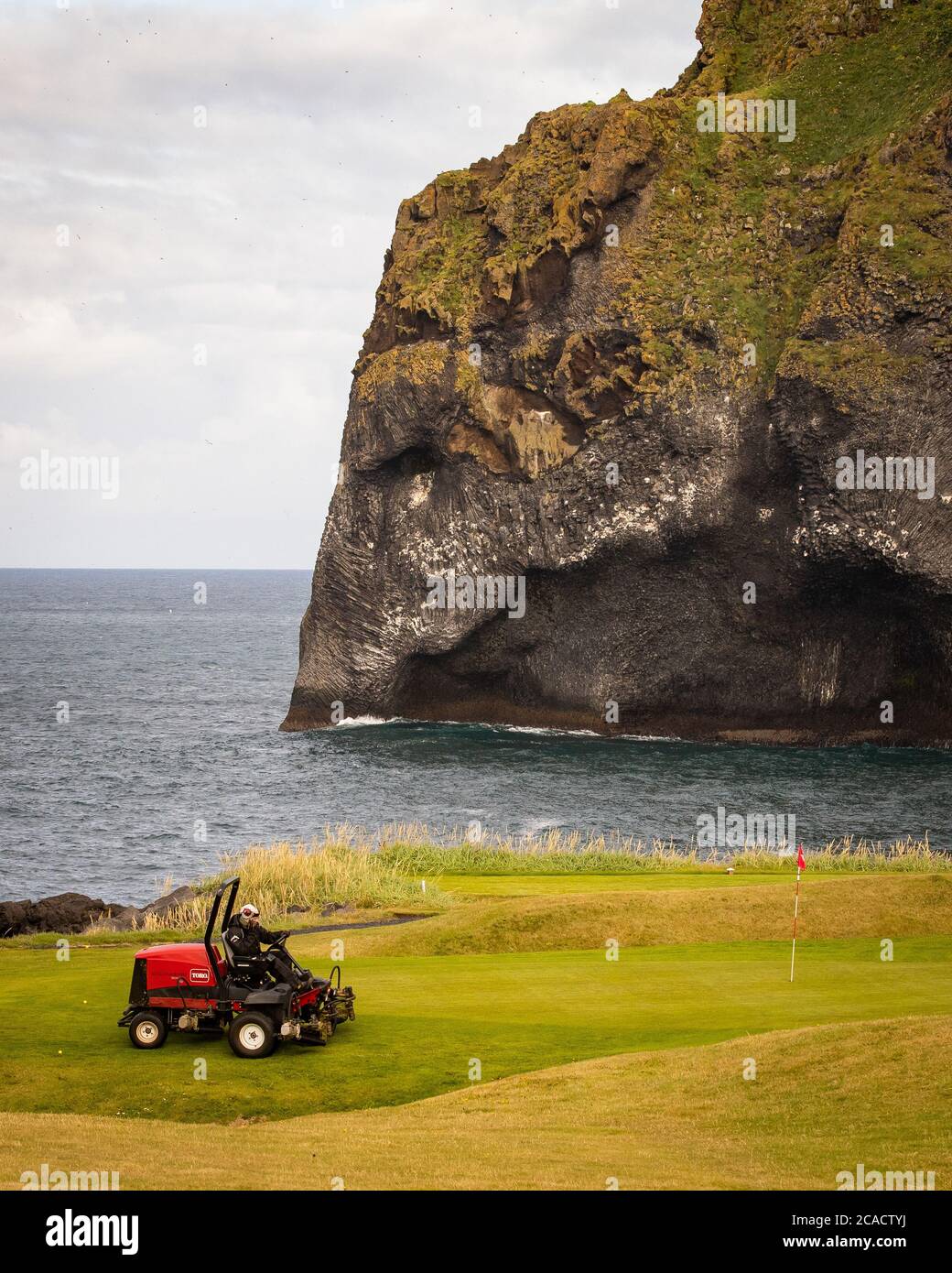 A grounds keeper tends to the Westman Island Golf Course on the island of  Vestmannaeyjar, in front of the Elephant Rock, a natural rock formation on  the Westman Islands archipelago, located approximately