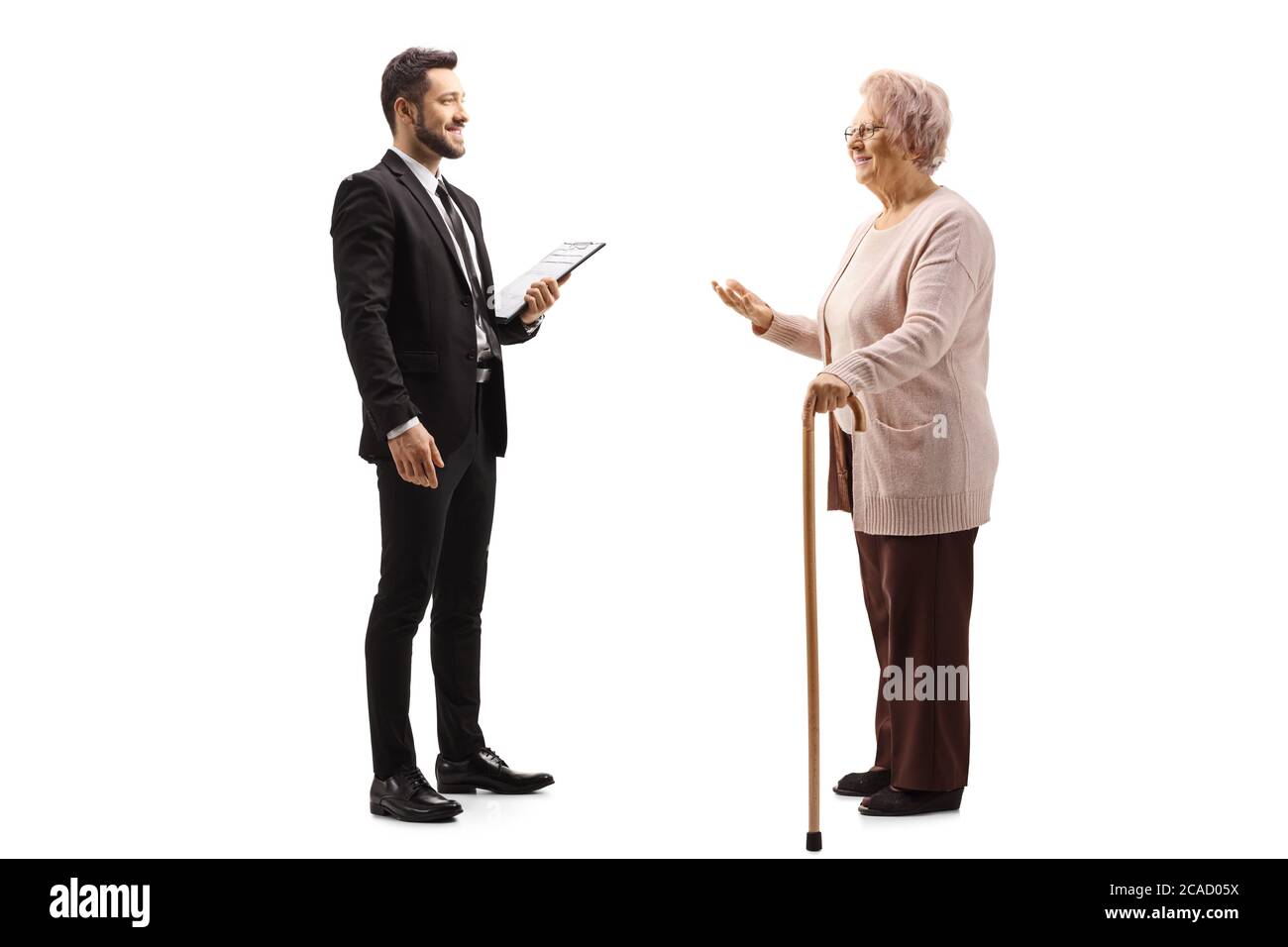 Full length profile shot of an elderly woman talking to a young elegant man in a suit isolated on white background Stock Photo