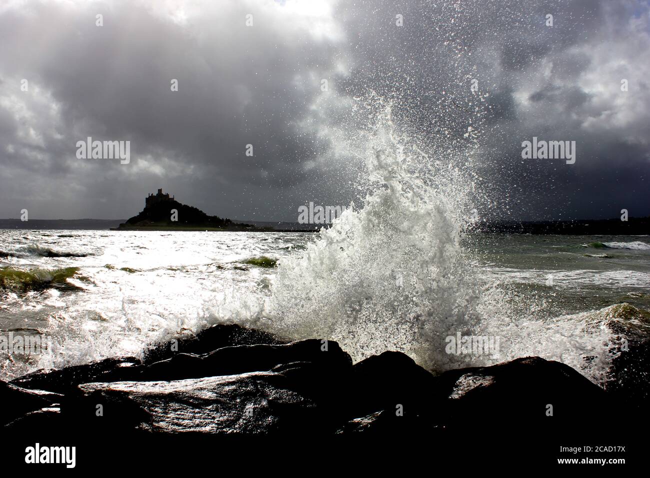crashing wave and St Michael's Mount Stock Photo